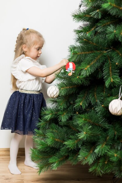 Piccola ragazza che decora l&#39;albero di Natale