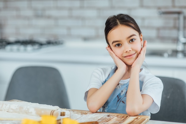 Piccola ragazza sorridente davanti in cucina