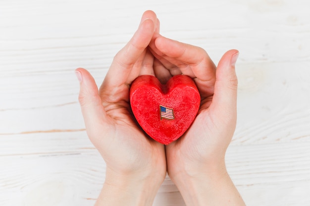 Piccola scatola regalo a forma di cuore in mano