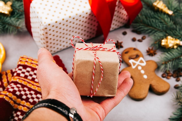 Piccola scatola regalo di Natale in mano dell&#39;uomo