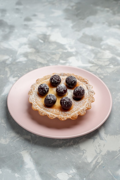 piccola torta con frutta all'interno della luce del piatto rosa, torta dolce da tè cuocere la torta