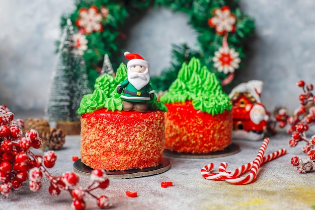 Piccola torta natalizia decorata con dolci figure di albero di natale, babbo natale e candele.