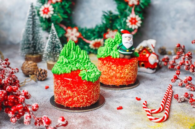 Piccola torta natalizia decorata con dolci figure di albero di natale, babbo natale e candele.