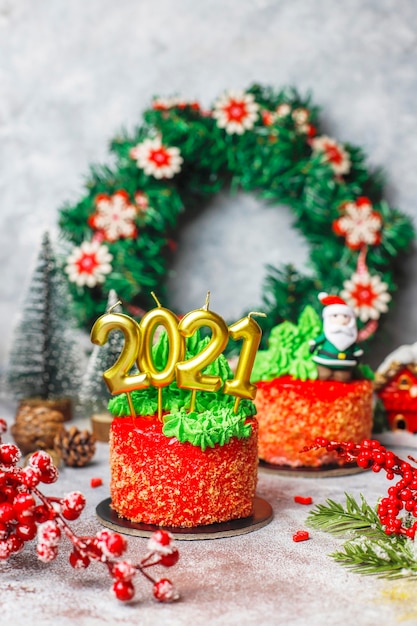 Piccola torta natalizia decorata con dolci figure di albero di natale, babbo natale e candele.