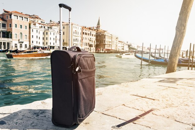 Piccola valigia su sfondo urbano di viaggio, Venezia, Italia. Orizzontale. Tonificante. Viaggi concetto di viaggio.