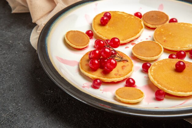 piccole frittelle con bacche rosse su oscurità