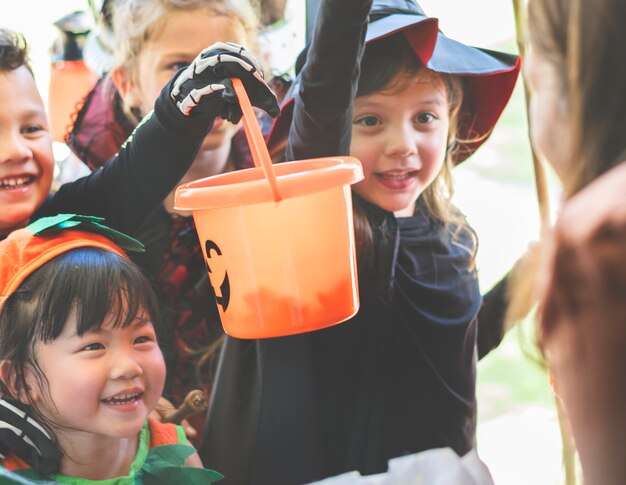 Piccoli bambini che fanno trucchi o dolcetti ad Halloween