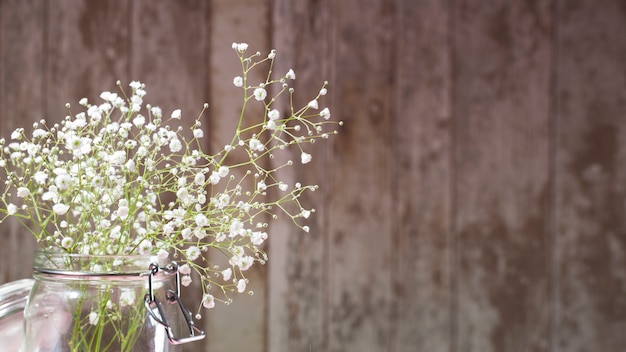 Piccoli fiori bianchi su fondo in legno