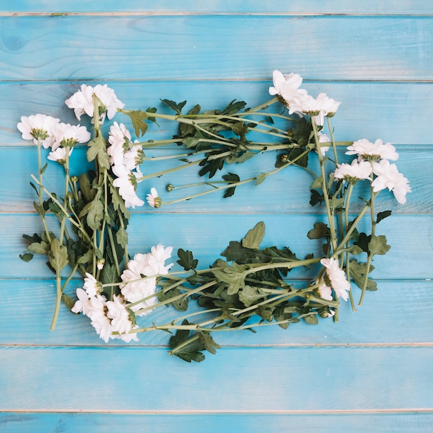 Piccoli fiori bianchi su legno blu