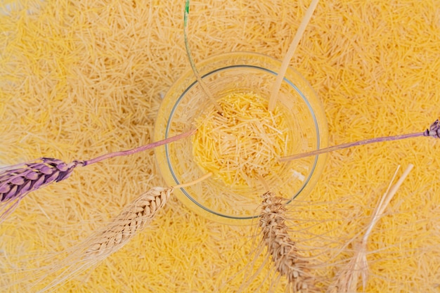 Piccoli vermicelli gialli con vaso di grani.