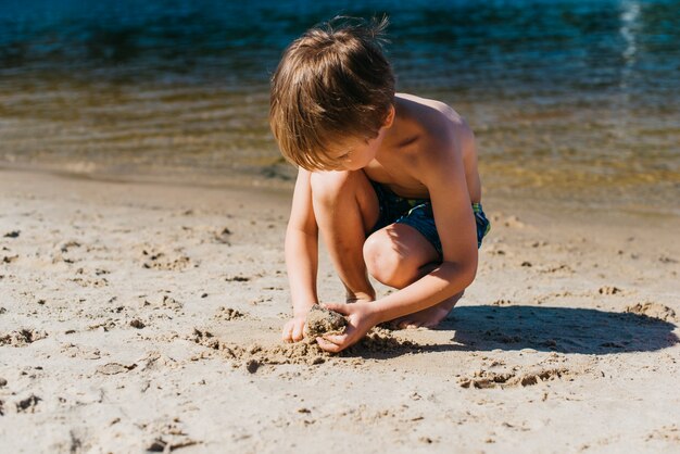 Piccolo bambino che gioca sulla spiaggia durante le vacanze estive
