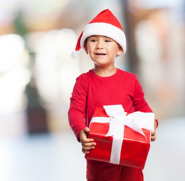 Piccolo bambino con un regalo rosso