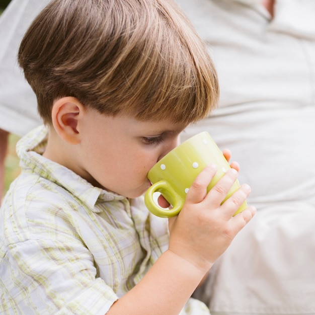 Piccolo bambino del primo piano che beve tè