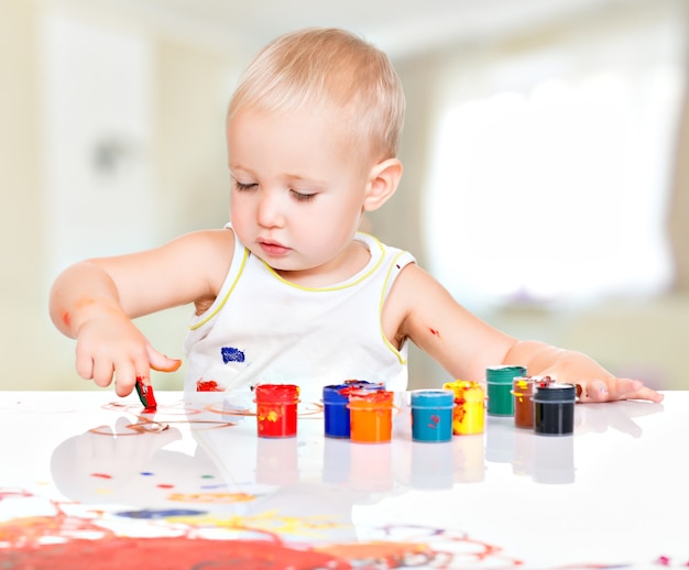 Piccolo bambino dipingere dalle sue mani a casa.