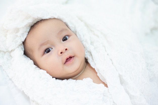 Piccolo bambino sveglio che esamina la macchina fotografica