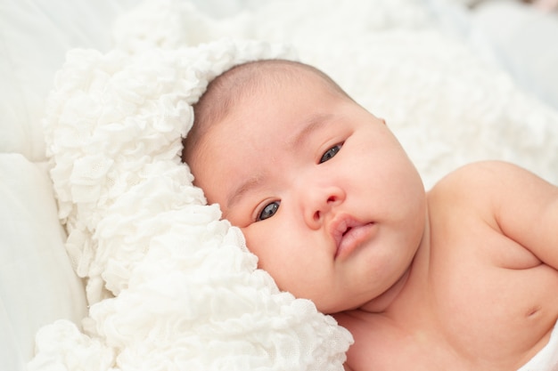 Piccolo bambino sveglio che esamina la macchina fotografica