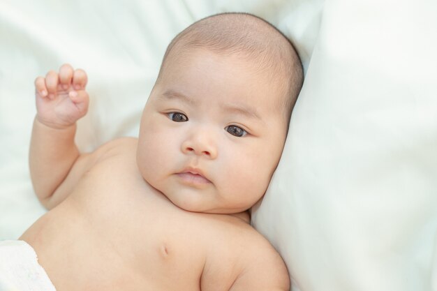 Piccolo bambino sveglio che esamina la macchina fotografica