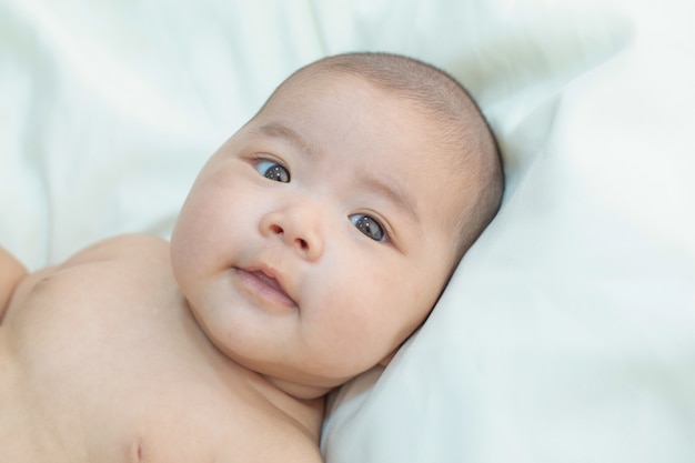 Piccolo bambino sveglio che esamina la macchina fotografica