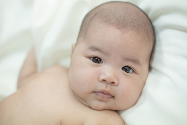 Piccolo bambino sveglio che esamina la macchina fotografica