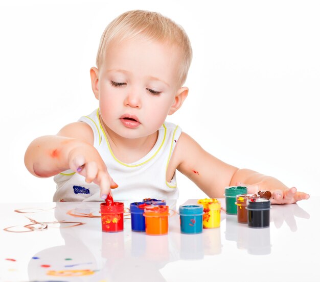 Piccolo bambino vernice dalle sue mani su bianco.
