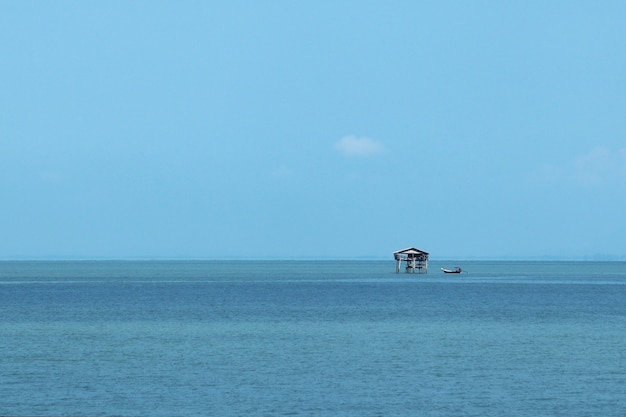 Piccolo edificio in mare sotto la luce del sole e un cielo azzurro di giorno