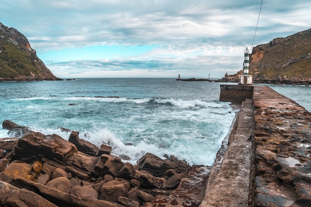 Piccolo faro a un molo di pietra in Pasajes San Pedro, Gipuzkoa, Spain