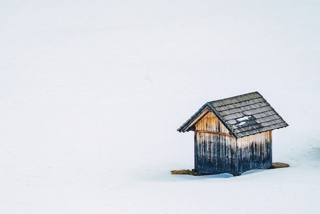 Piccolo fienile in legno in un campo nevoso