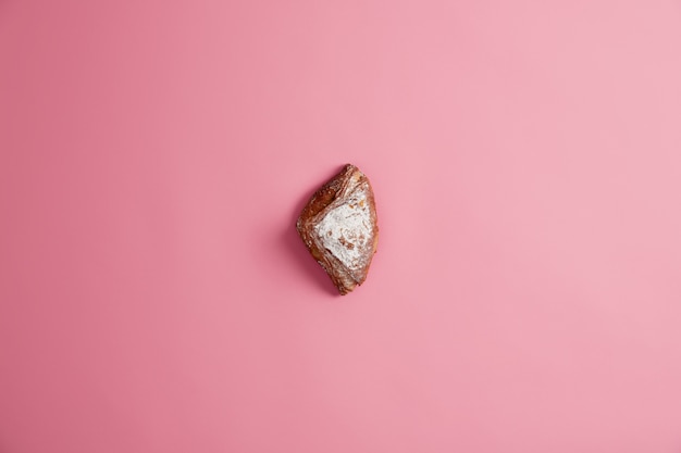 Piccolo panino al forno morbido fresco dolce scintillante di zucchero, isolato su sfondo rosa. Pasticceria. Delizioso dessert per colazione o cena. Alimentazione malsana, cibo contenente molte calorie