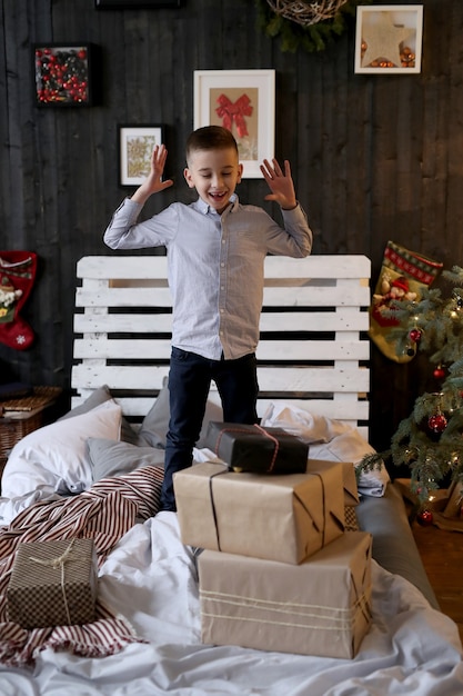 Piccolo ragazzo scioccato con i regali di Natale