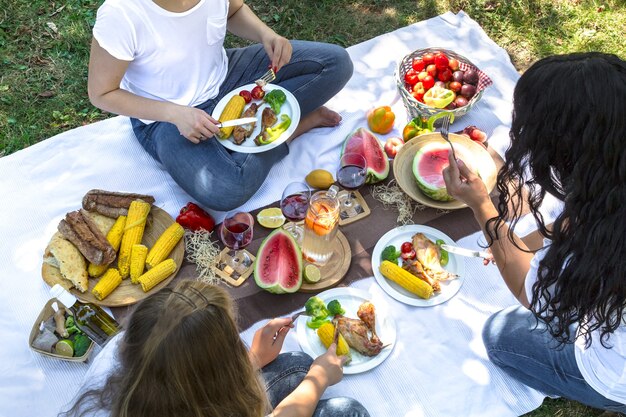 Picnic estivo con gli amici nella natura con cibo e bevande.