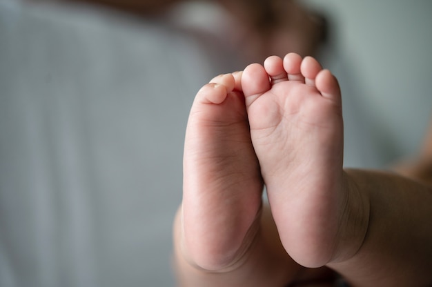 Piedi del bambino nel letto bianco.