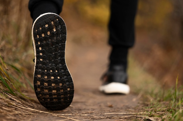 Piedi del maschio del primo piano nella foresta