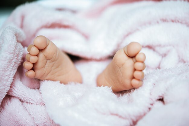 Piedi del neonato su una coperta bianca