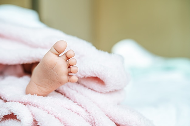 Piedi del neonato su una coperta bianca