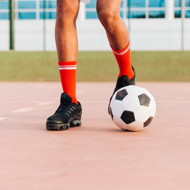 Piedi dello sportivo che giocano a calcio allo stadio