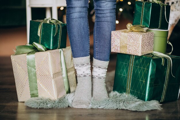 Piedi femminili in calzini con regalo di Natale tutto intorno