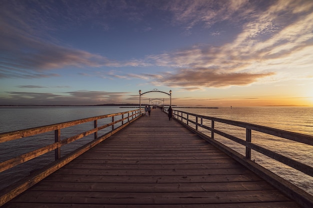 Pier e il mare blu durante un tramonto panoramico