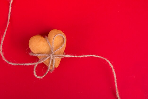 Pila di biscotti a forma di cuore sul tavolo rosso