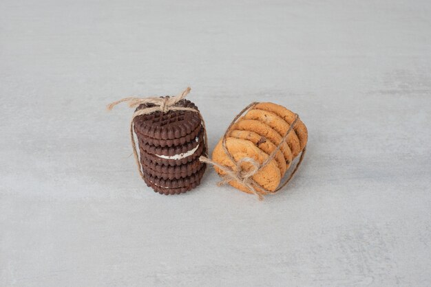 Pila di biscotti legati con la corda sulla tavola bianca.