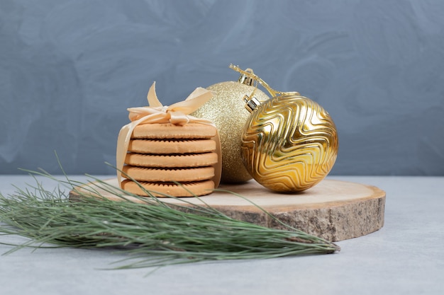 Pila di biscotti legati con nastro e palle di Natale su tavola di legno. Foto di alta qualità