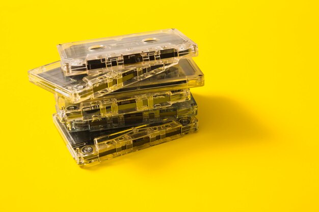 Pila di cassette audio trasparente su sfondo giallo