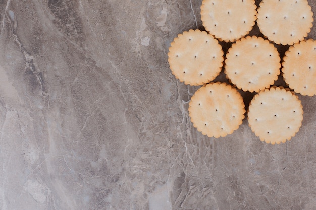 Pila di cracker rotondi sulla superficie di marmo.