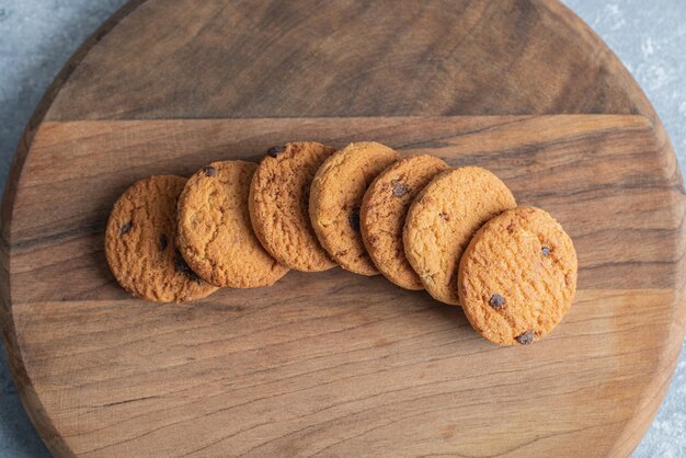 Pila di deliziosi biscotti con scaglie di cioccolato su tavola di legno