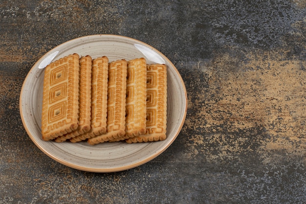 Pila di gustosi biscotti sul piatto in ceramica.