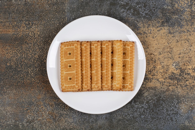 Pila di gustosi biscotti sulla piastra bianca.