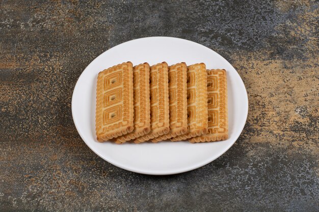 Pila di gustosi biscotti sulla piastra bianca.