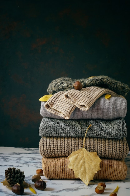 Pila di maglioni a maglia accoglienti. Concetto autunno-inverno, maglioni di lana lavorati a maglia. Mucchio di abiti invernali a maglia, maglioni, maglieria