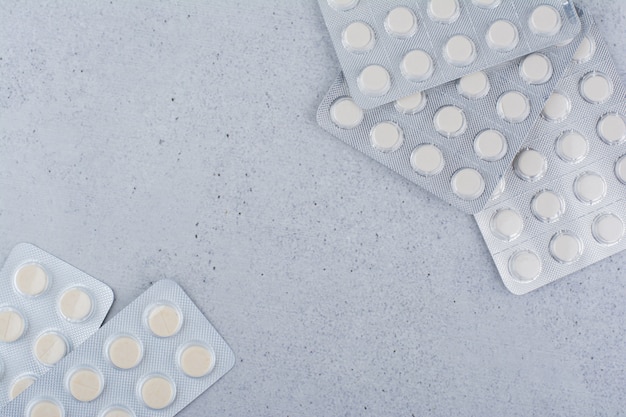 Pila di pillole mediche su sfondo marmo.