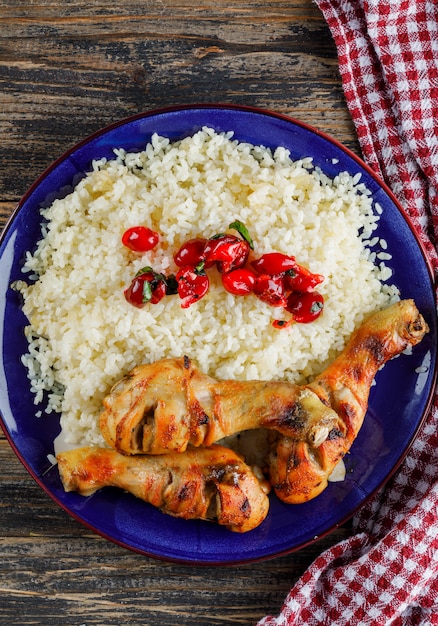 Pilaf in un piatto con carne di pollo, mirtilli rossi sul telo in legno e cucina