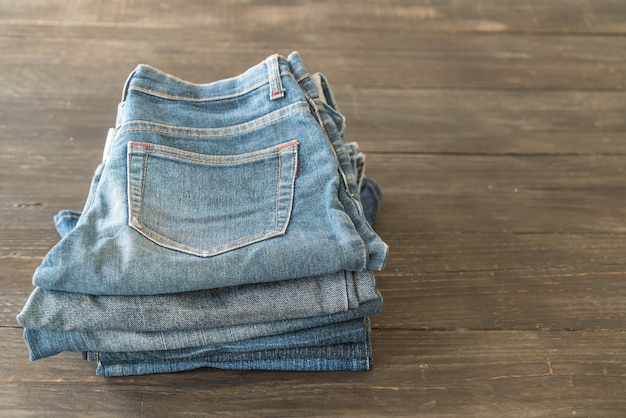 pile di jeans abbigliamento su legno